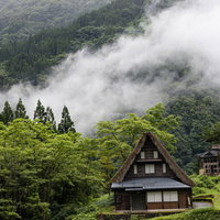 大きな霧が立ち込める渓谷に建つ相倉集落の合掌造りの写真