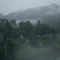濃霧に覆われた渓谷の町、山裾に点在する住宅が霞む南砺市の写真