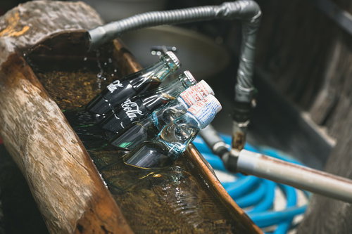 氷の上に置かれた冷えたコーラとラムネの瓶