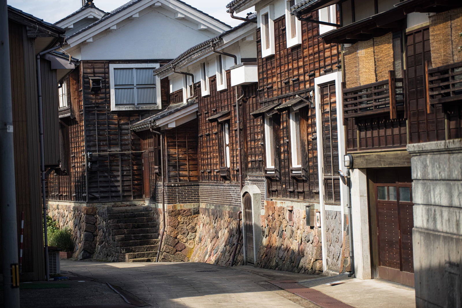 石畳の小路に並ぶ伝統的な蔵造りの建物と蔵回廊の風景