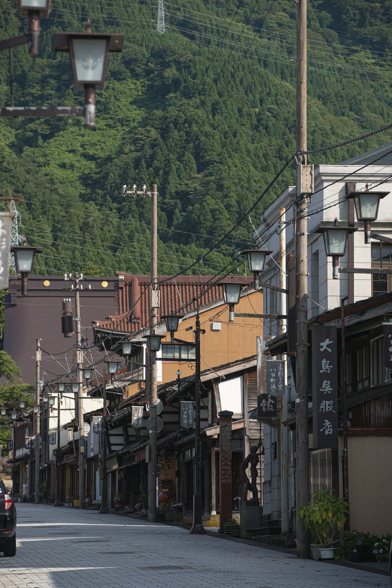 石畳の八日町通りに軒を連ねる古い建物群と電柱が見える街並み