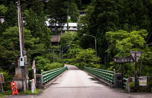 五箇山の流刑小屋へ続く緑の木橋を歩む歴史の道