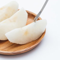 カットした梨とフォーク、木皿に並ぶの写真