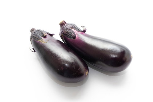 白背景に並ぶ紫色の茄子2本、新鮮な野菜