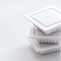 白い背景に積み重ねられた納豆パック3セットの写真