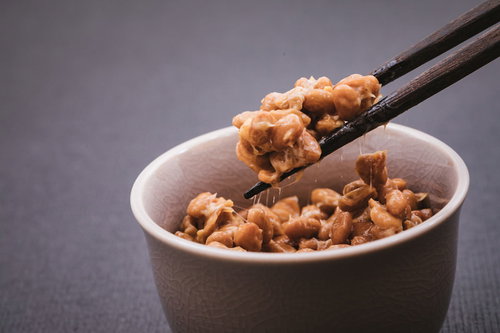 小鉢の納豆をつかむ箸と糸引き