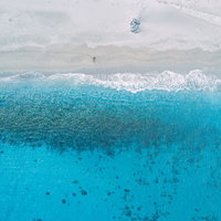 砂浜の足跡が残る神津島多幸湾の海と白砂ビーチの写真