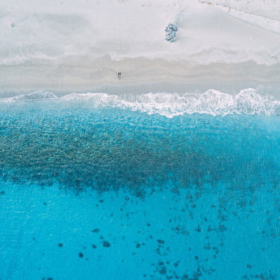 砂浜の足跡が残る神津島多幸湾の海と白砂ビーチの写真