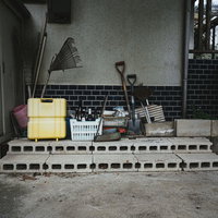 廃屋の古いブロック塀とスコップが置かれた倉庫の写真