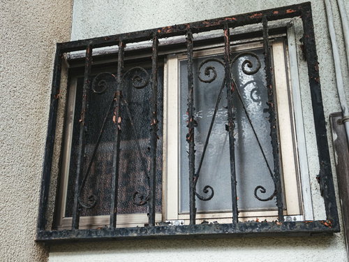 錆びて塗装が剥げた古い鉄格子（廃屋の窓枠）