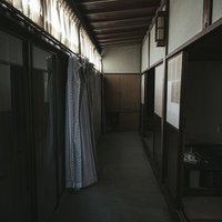 雨戸がすべて閉まった昭和レトロな空き家の薄暗い民家の写真