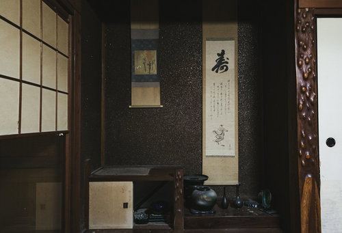 掛け軸が飾られた和室の座卓と茶器
