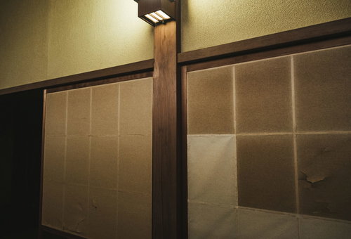 破けたふすま紙を照らす間接照明：古い和室の不気味な光と影