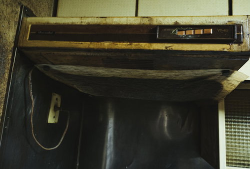 掃除を怠った昭和レトロな台所の換気扇と油汚れ