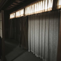 昭和民家の室内に掛けられた色違いのカーテンの写真