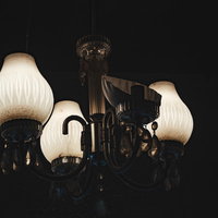 暗い廃屋に吊り下がる割れたシャンデリアの廃墟インテリアの写真