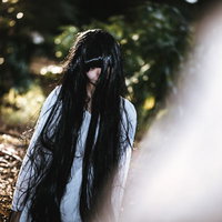 呆然と立ちすくむ不気味な長い黒髪の女性の写真