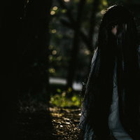 目が合ったら呪われる暗闇で凝視する女性の恐怖の顔の写真