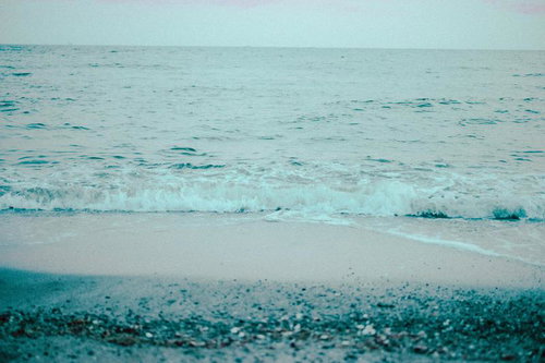 小石の浜に寄せる穏やかな波打ち際の海風景