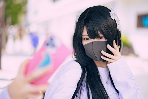 スマートフォンを構えた自撮りするマスク女子