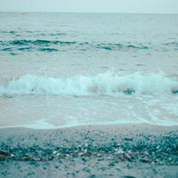 波打ち際で砕ける波の海岸線風景、白波と砂利浜の写真