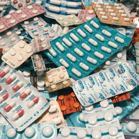 錠剤やカプセルなどの処方薬が大量に散らばった状態の写真