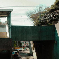 コンクリートの壁が囲む高架下の車道と都市の日常の写真