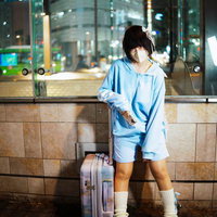 出稼ぎ天使系女子、夜景のビルの前でキャリーケース待機の写真