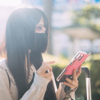 スマートフォンを持つマスクする地雷系女子の写真