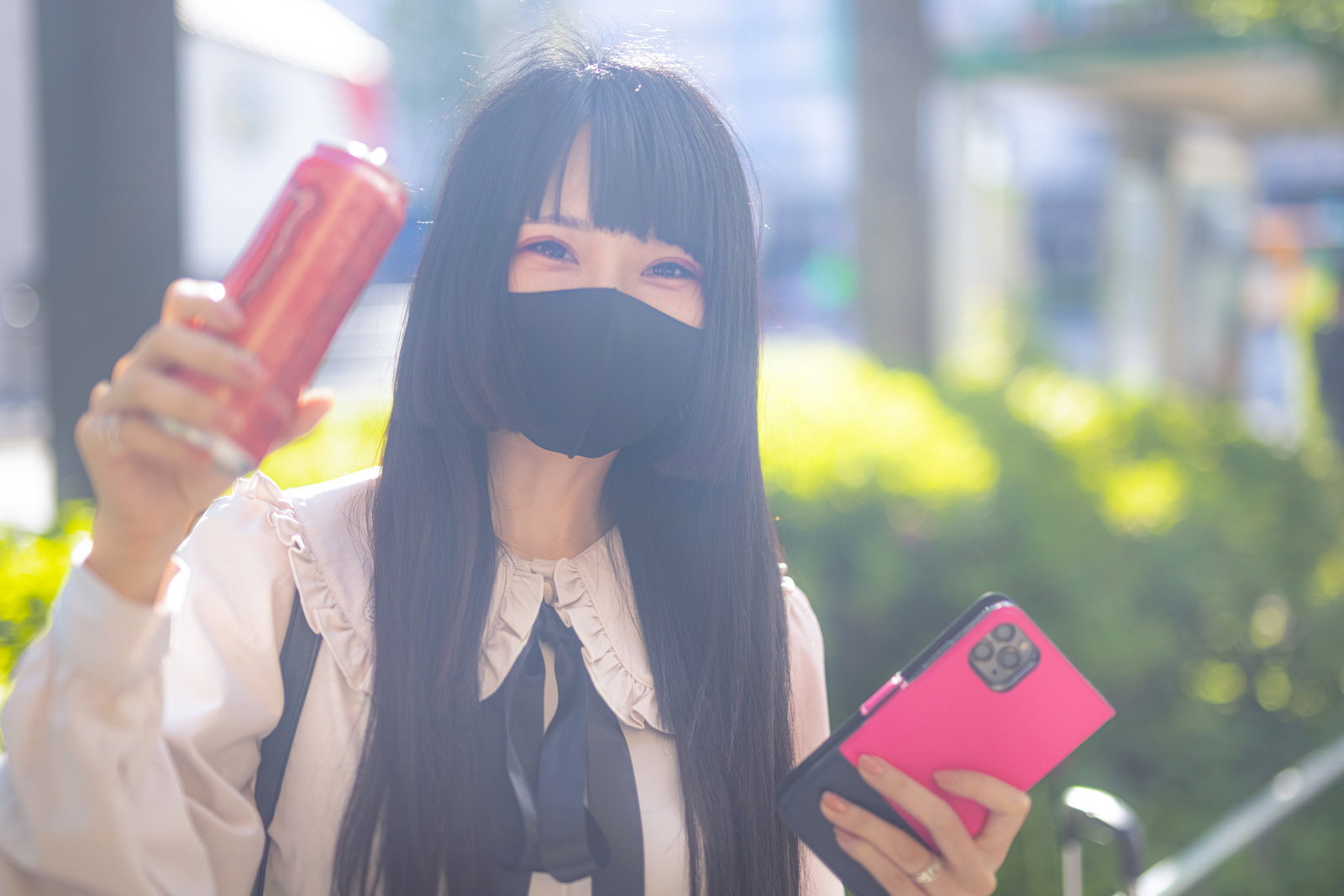 マスクをした黒髪の地雷系女子がピンク色のアイテムを持ってピースサイン［モデル：緋真煉］
