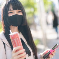黒マスク姿でピンモンを持つ待ち合わせ女性の写真