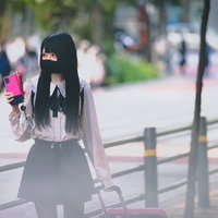 キャリーケースを引きずりながら歩く地雷系女子の写真