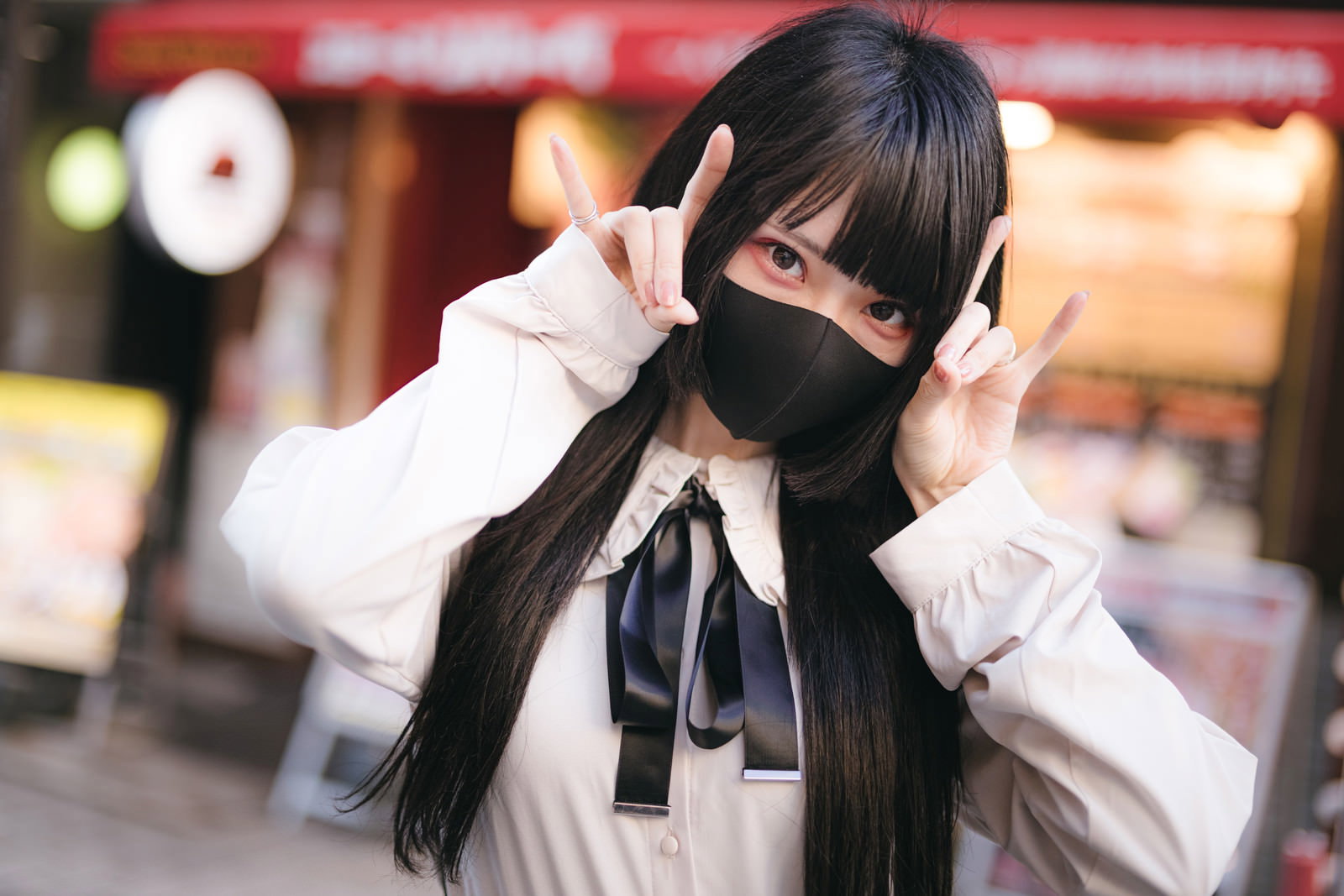 黒いマスクをして白い服を着た地雷系女子が両手で顔を覆っている［モデル：緋真煉］