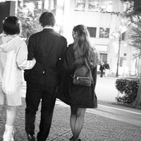 夜の街を歩くダブルデートのカップル、男性と女性の後ろ姿の写真