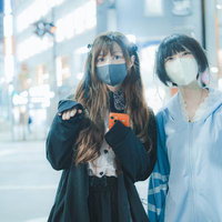 都会の街中で客引きするマスク女子の夜間営業宣伝の写真
