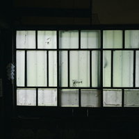 古民家の古い引き戸、薄暗い室内から見える汚れの目立つガラス窓の写真