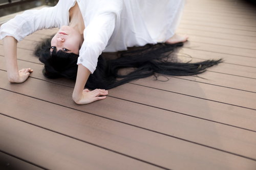 木製デッキでブリッジポーズを行う女性