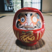 THE赤いだるま（片目）畳の上に置かれた伝統的な開運置物の写真