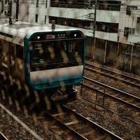 金網越しに見る都会の電車（総武線）の写真