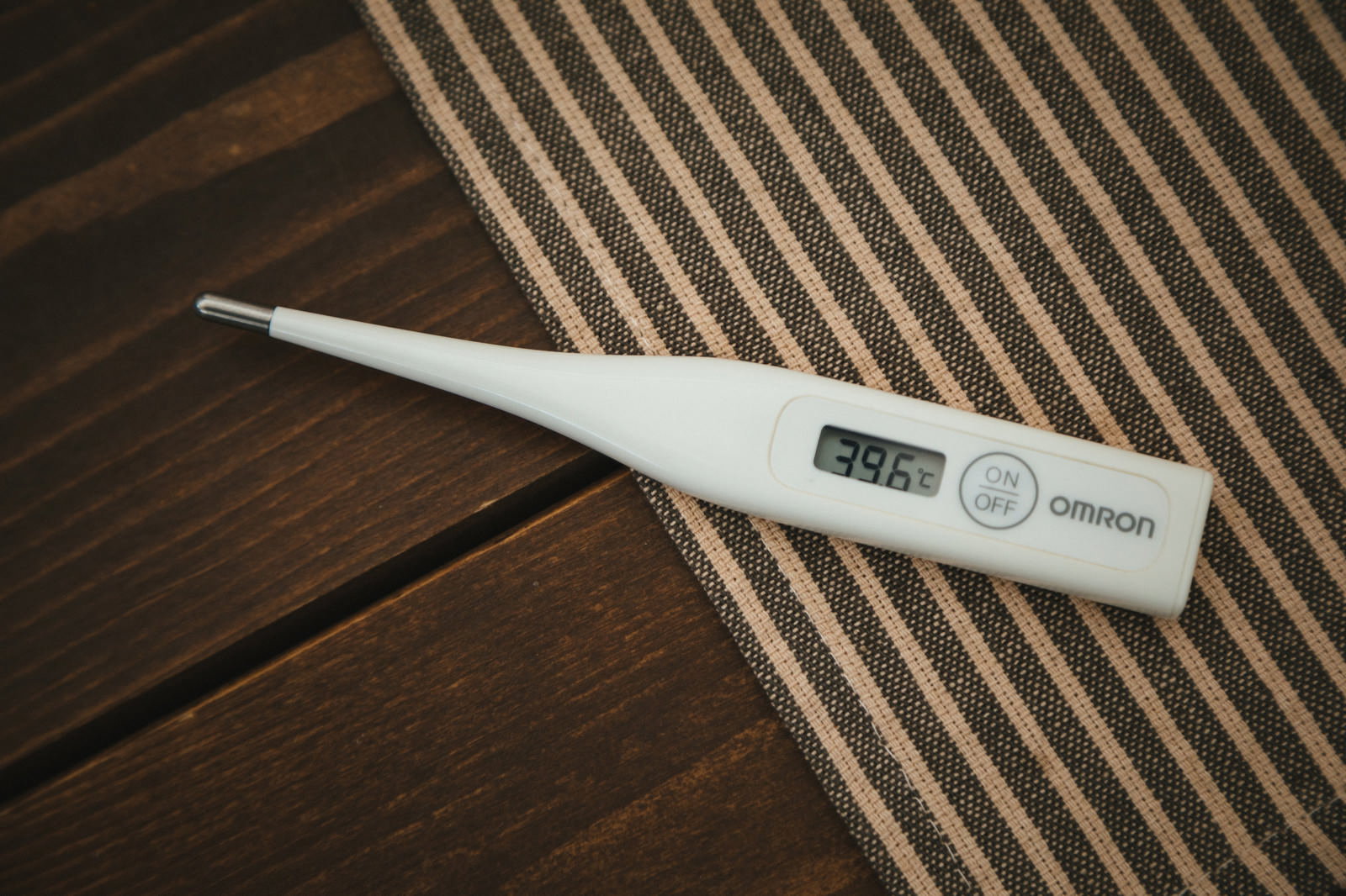 39.6℃表示の体温計と診断書と錠剤