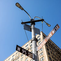 ニューヨークの青空に立つ指導標と街灯、高層ビルの写真