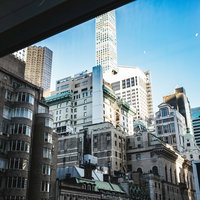 窓枠越しに見るニューヨークの高層ビルと街並みの写真
