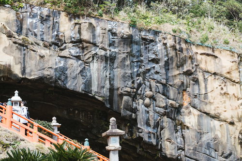 どこかに顔が隠れてる鵜戸神宮の神殿を覆う岩壁と滴る湧き水