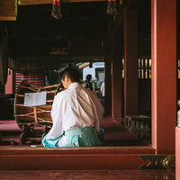 鵜戸神宮の本殿で白い装束の宮司が横笛を吹く儀式の写真