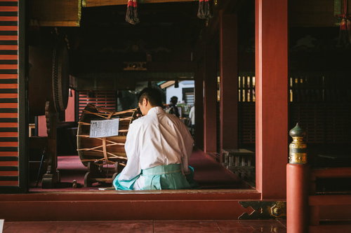 鵜戸神宮の本殿で白い装束の宮司が横笛を吹く儀式