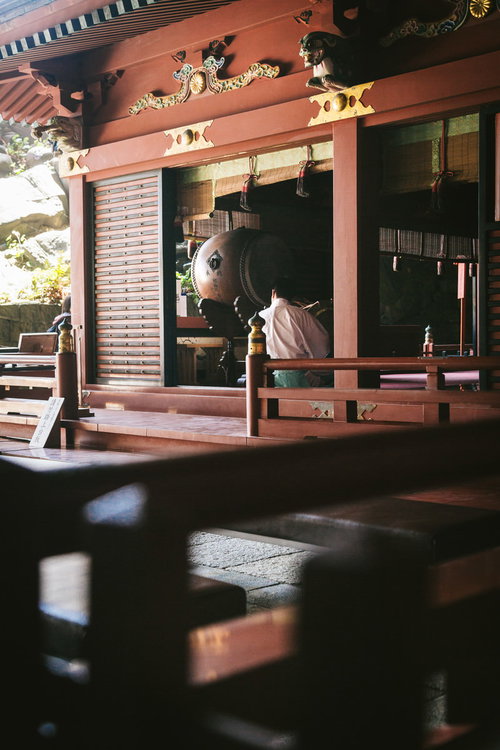 鵜戸神宮の朱塗りの神殿内部と神職による参拝風景