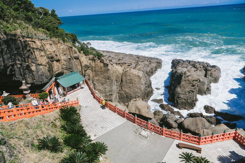 絶壁に囲まれた岩窟の鵜戸神宮の朱色の社殿と参拝風景