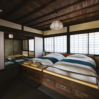 リノベーションした古民家の寝室、木の梁とモダンベッドの写真