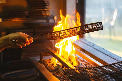 油を垂らしながら炭火で焼く地頭鶏の焼き鳥