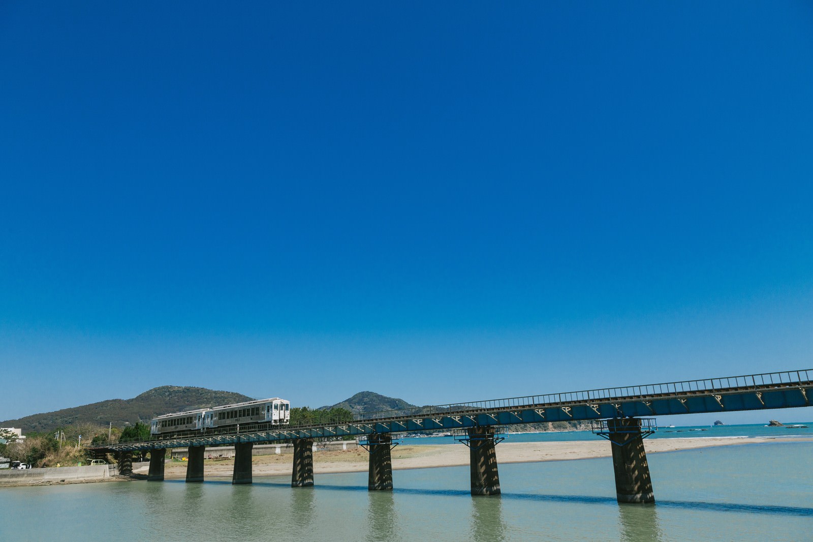 宮崎県日南市の鉄橋を渡る白い観光列車「海幸山幸」